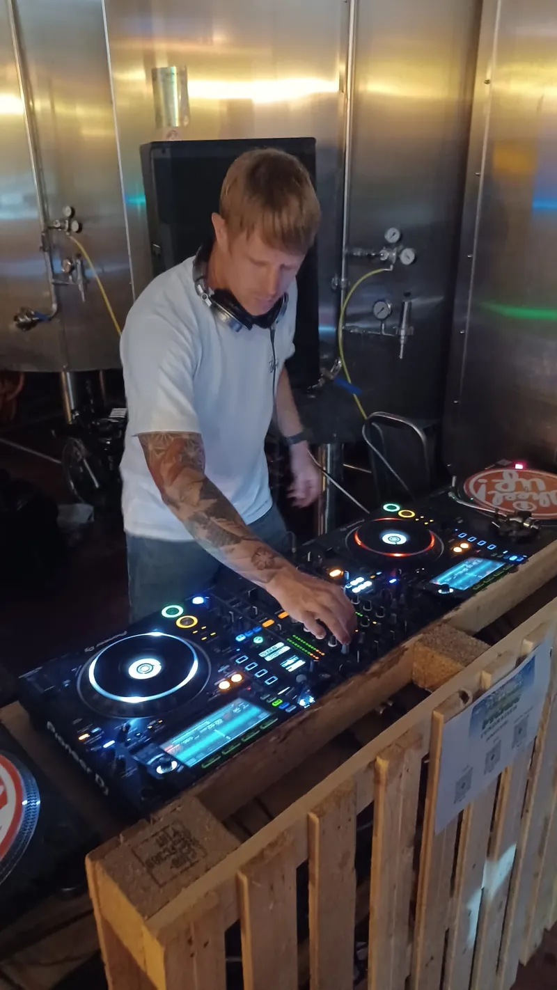 Bring The Beat Mack DJing on Pioneer decks in a brewery, surrounded by steel tanks
