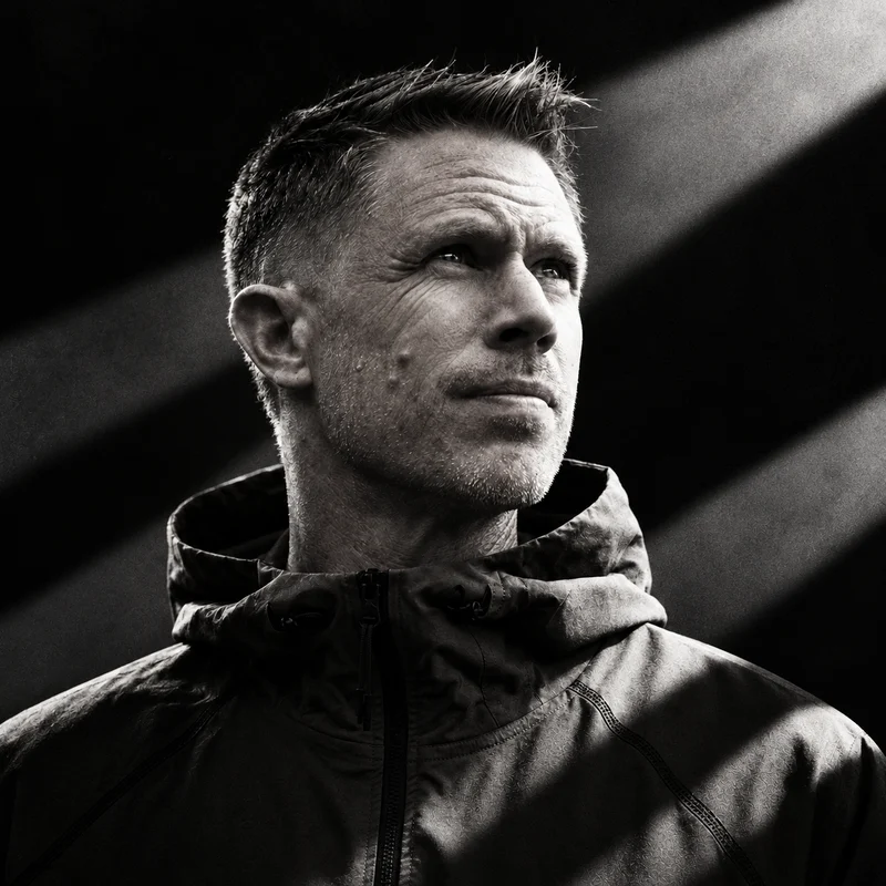 Black and white portrait of Bring The Beat Mack in a hooded jacket, looking up